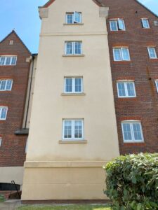 Algae growth on commercial building render in Kent after soft washing
